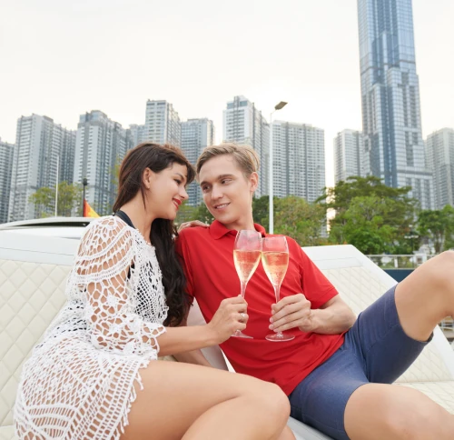 young couple relaxing with champagne and skyline view in modern city