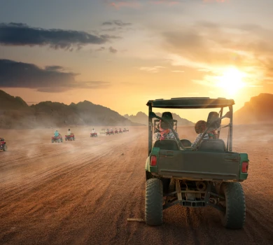 tourists riding desert buggy during sunset adventure in sand dunes
