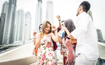 friends enjoying drinks at a yacht party in dubai marina skyline