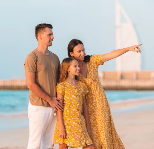 family enjoying jumeirah beach with burj al arab in background