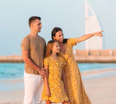 family enjoying jumeirah beach with burj al arab in background