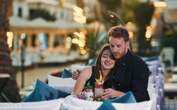 romantic couple enjoying drinks at luxury outdoor restaurant at night
