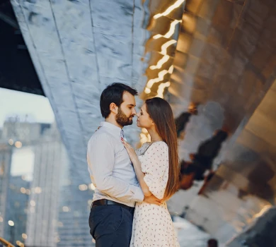 romantic couple standing together under modern architecture in city