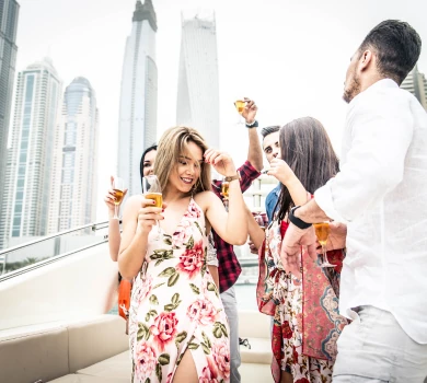 friends enjoying drinks at a yacht party in dubai marina skyline