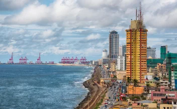 Colombo coastal city skyline with ocean and port cranes