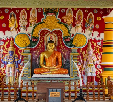 Colourful Buddhist temple interior with large seated Buddha statue