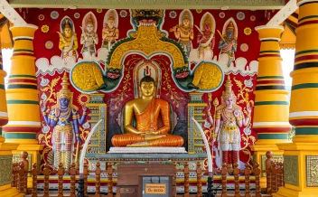 Colourful Buddhist temple interior with large seated Buddha statue