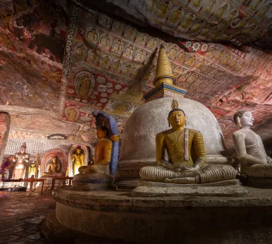Golden Buddha statues inside Dambulla Cave Temple with painted ceiling